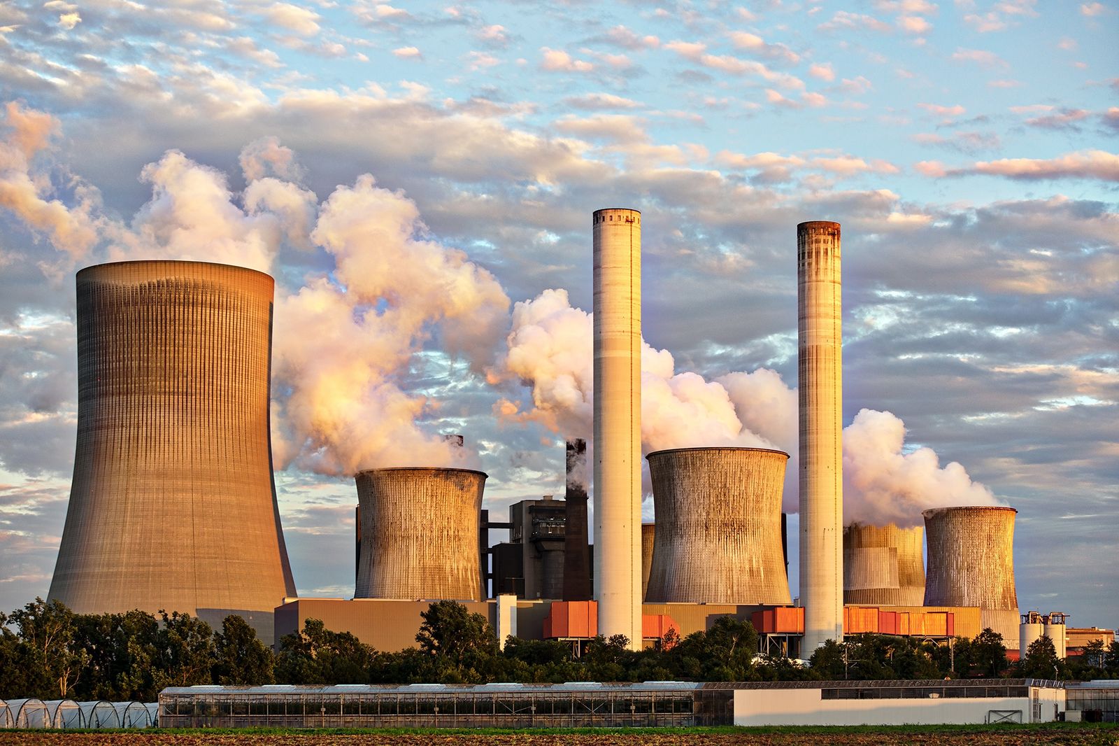 Power plant stacks with flue gas plumes at sunset: industrial emissions and DeNOx control